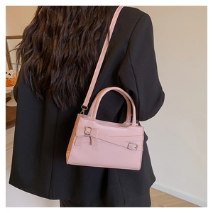 Pink leather handbag with bow detail shown on black blazer for high contrast style