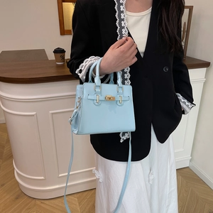 Sky blue large capacity leather tote bag with gold lock and shoulder strap on model