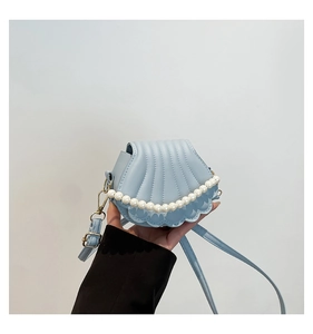 Détail du sac coquillage bleu clair avec perles blanches et bandoulière réglable