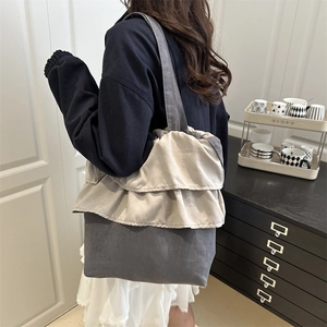 Large gray canvas tote bag with beige ruffle trim and a comfortable shoulder strap