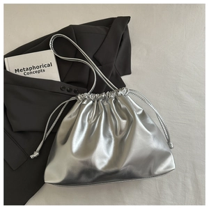 Detailed top view of a silver metallic drawstring bucket bag with soft pleated texture