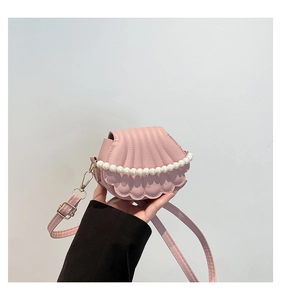 Détail d'un sac bandoulière rose en forme de coquillage avec perles et bords ondulés