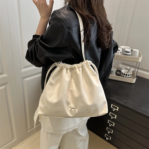 Chic cream white drawstring tote bag with glossy finish and silver bow charm for women