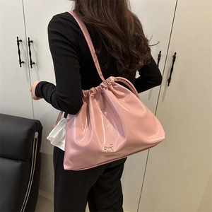 Pink drawstring cloud bucket bag with silver bow detail and glossy finish tote