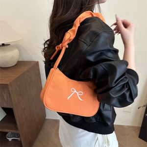 Orange pleated shoulder bag with white bow embroidery and adjustable ruched strap