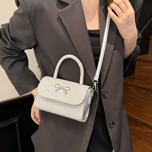 Elegant silver sequin crossbody bag with bow detail and adjustable shoulder strap