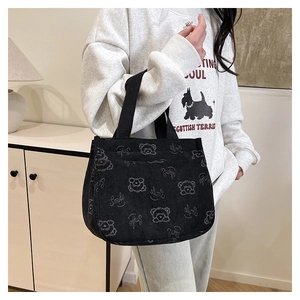 Détail du sac cabas en velours côtelé noir avec imprimé ours cartoon et texture douce