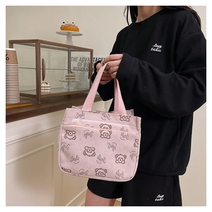 Sac fourre-tout en velours côtelé rose avec imprimé ours et poche zippée dans un café