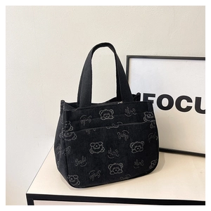 Détail du sac cabas en velours côtelé noir avec motif ours et texture du tissu