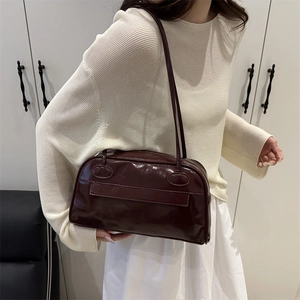Large dark brown shiny bowling bag for women featuring multiple pockets and shoulder straps