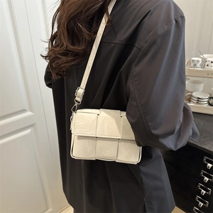 Women's white woven shoulder bag made of synthetic leather with a stylish flap closure