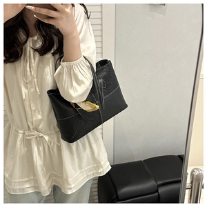 Large black tote bag featuring snakeskin texture and yellow silk scarf on the handle