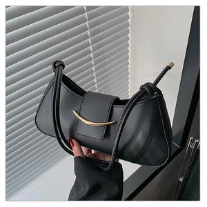 Close-up of black matte crescent shoulder bag with minimalist golden metal hardware detail