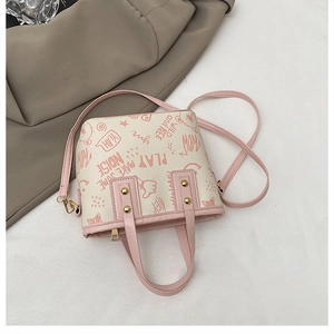 Detail of contrast tote bag with pink graffiti art print and golden rivet accents