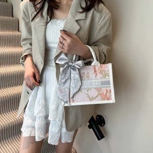 Mini pink tote bag with floral embroidery, white ribbon logo and silk scarf on handle