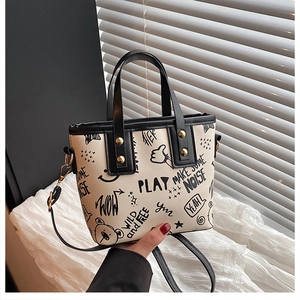 Detail of the graffiti print tote bag with black piping and gold-toned rivets decoration