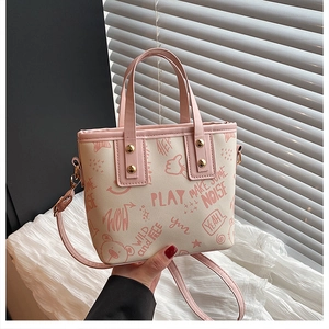 Close-up of contrast tote bag with pink cartoon graffiti, bear print and gold rivets