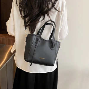 Chic black matte leather bucket bag with top handles and adjustable shoulder strap