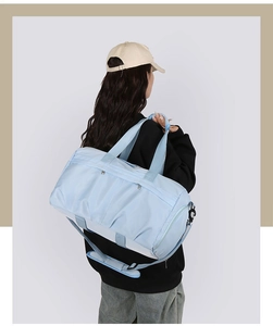 Detalle de la bolsa de viaje grande azul claro con correa ajustable y textura de nylon