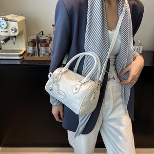 Elegant white snakeskin embossed Boston bag with pearl bow charm and top handle