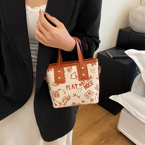 Chic cream tote bag with orange graffiti patterns and brown leather handles for women