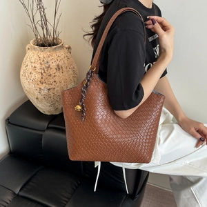 Sac fourre-tout en cuir tressé marron foncé avec bandoulière et pendentif cloche dorée