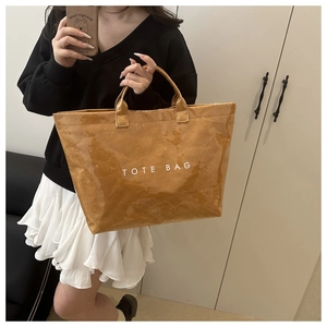 Detail of a large brown tote bag with retro wrinkled texture and waterproof PVC coating