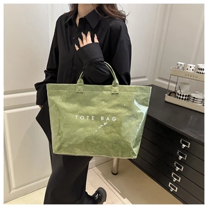 Detail of green glossy tote bag with white text print and unique crinkle texture finish