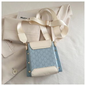 Detail view of mini crossbody phone bag in blue and white leather with rivet studs