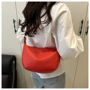 Vue mannequin d'un sac porté épaule rouge en demi-lune avec lettrage doré sur blanc
