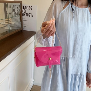 Petit sac bandoulière rose transparent en PVC avec chaîne dorée porté par un mannequin