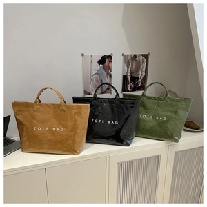 Detailed view of large tote bags in brown, black, and green with a unique crinkled texture