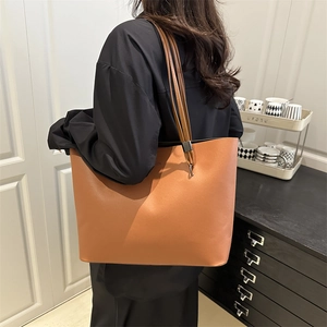 Grand sac cabas minimaliste en cuir marron ambre porté à l'épaule pour femmes
