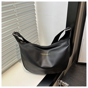 Détail du sac croissant noir avec boucles en métal doré et bandoulière ajustable
