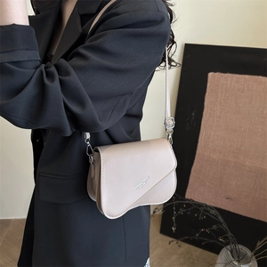 Minimalist beige crossbody square bag with curved flap and adjustable shoulder strap