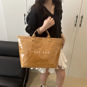 Caramel brown high-gloss large tote bag with white TOTE BAG text shown with model