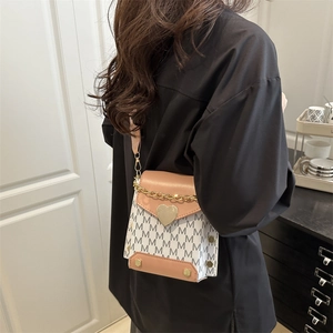 Vintage crossbody mini bag with heart lock and M-letter print on model in casual setting