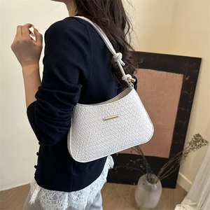 Elegant white textured underarm bag with gold metal trim and stylish knotted strap
