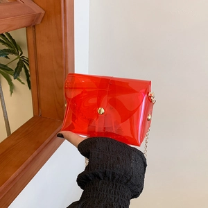 Sac enveloppe rouge transparent en PVC avec bandoulière chaîne et rivets dorés