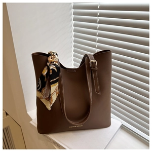 Détail du sac cabas marron foncé avec nœud en soie et boucles métalliques