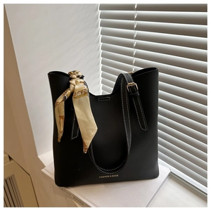 Détail du sac cabas noir avec surpiqûres blanches et boucle en métal doré élégante