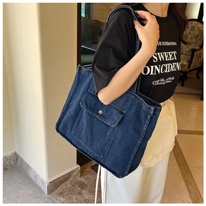 Detail einer Vintage-Denim-Tragetasche mit einer Vordertasche und goldener Schnalle