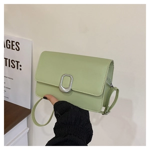 Detail view of the mint green rectangle crossbody bag with oval silver metal buckle clasp