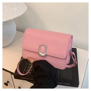 Detail of pink crossbody bag showing silver oval twist lock and smooth synthetic leather