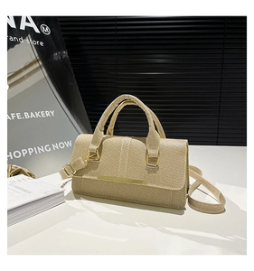 Détail du sac à main beige rectangulaire avec texture en toile et accents en métal doré