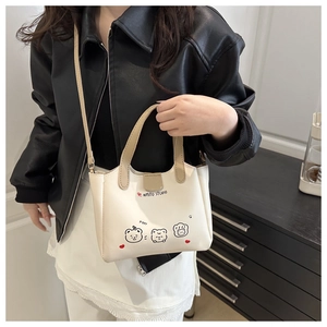 Gros plan du sac fourre-tout en cuir PU crème avec motifs d'ours et poignée supérieure