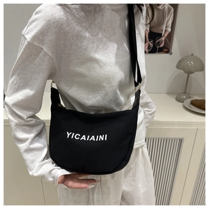 Détail du sac bandoulière demi-lune en toile noire avec texte YICAIAINI et sangle large