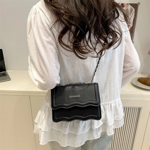 Elegant black leather crossbody bag with wavy flap design and metal chain strap for women