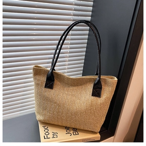 Detailed weave pattern and black faux leather handle of this beige straw tote bag
