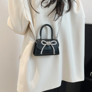 French style black mini crossbody bag with a rhinestone bow and silver chain strap